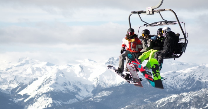 Auslands-Reisekrankenversicherung Winter Snowboarder Lift Berge Auslandsreisekrankenversicherung
