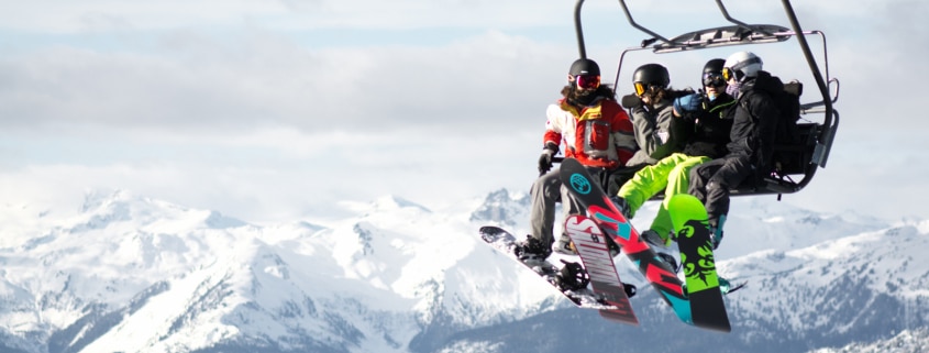 Auslands-Reisekrankenversicherung Winter Snowboarder Lift Berge Auslandsreisekrankenversicherung